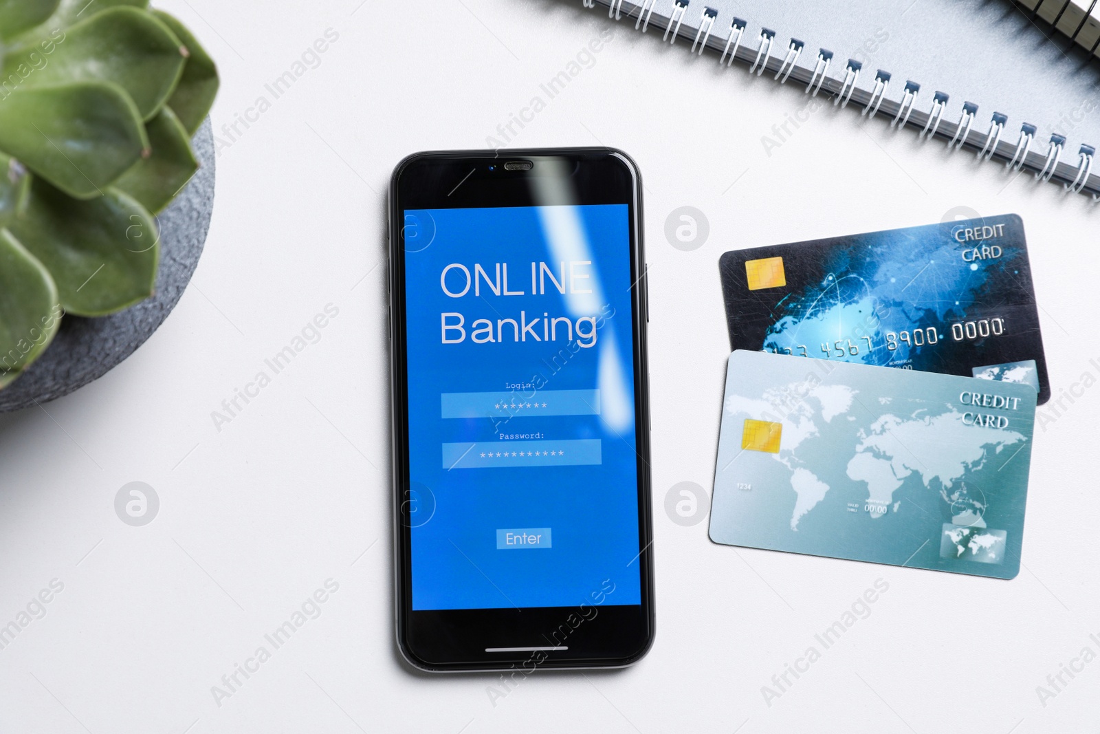 Photo of Smartphone with online banking app and credit cards on white office table, flat lay