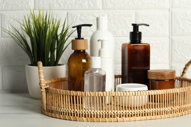 Bath accessories. Personal care products on white table near brick wall