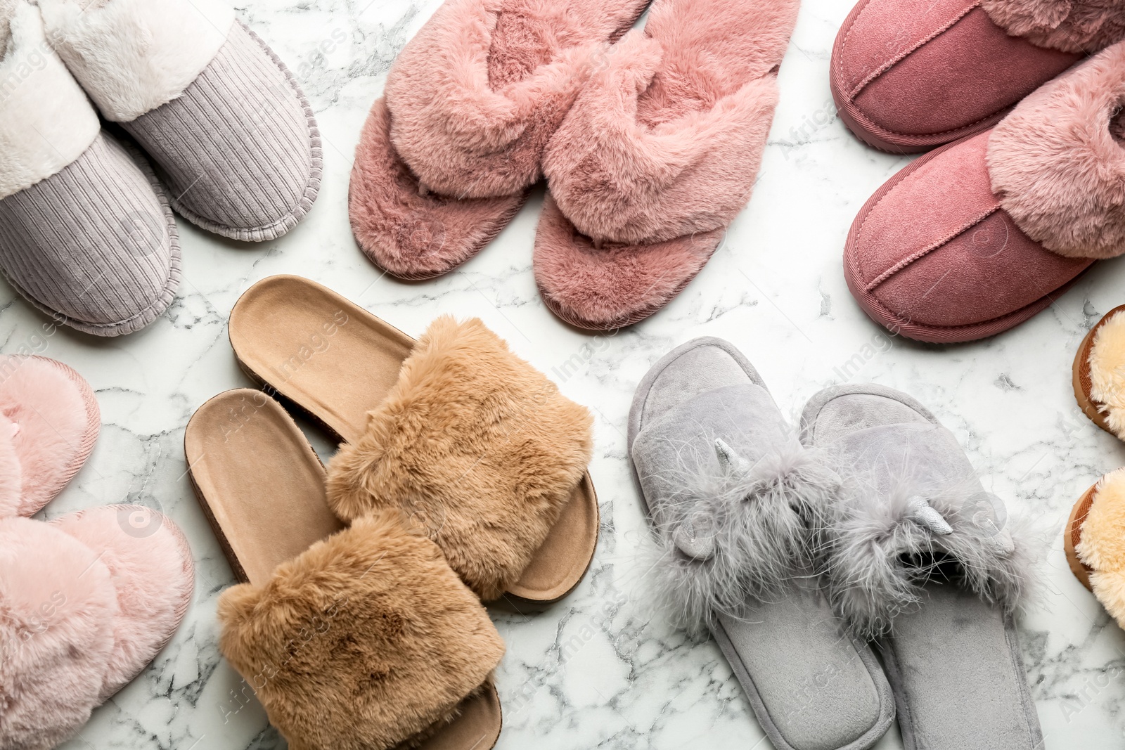 Photo of Many different soft slippers on white marble background, flat lay
