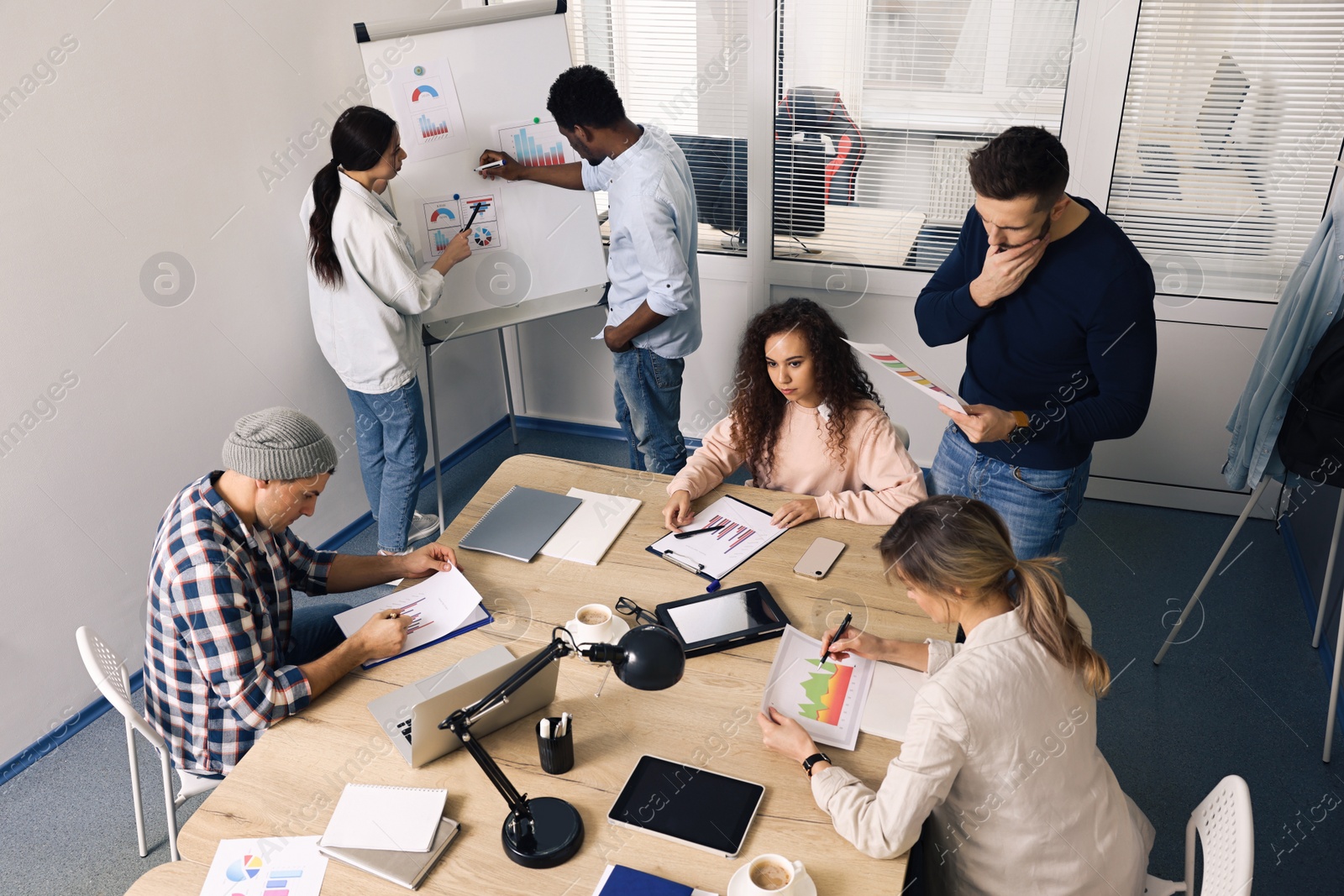 Photo of Team of employees working together in office. Startup project