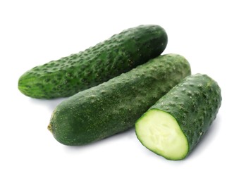 Photo of Whole and cut cucumbers on white background