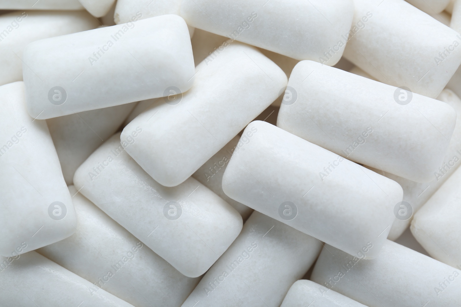 Photo of Tasty white chewing gums as background, top view