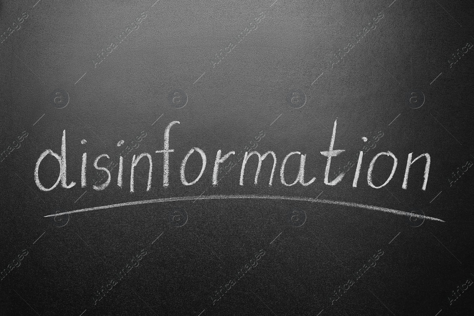 Photo of Word DISINFORMATION written on blackboard, closeup view