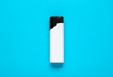 Photo of White plastic cigarette lighter on light blue background, top view