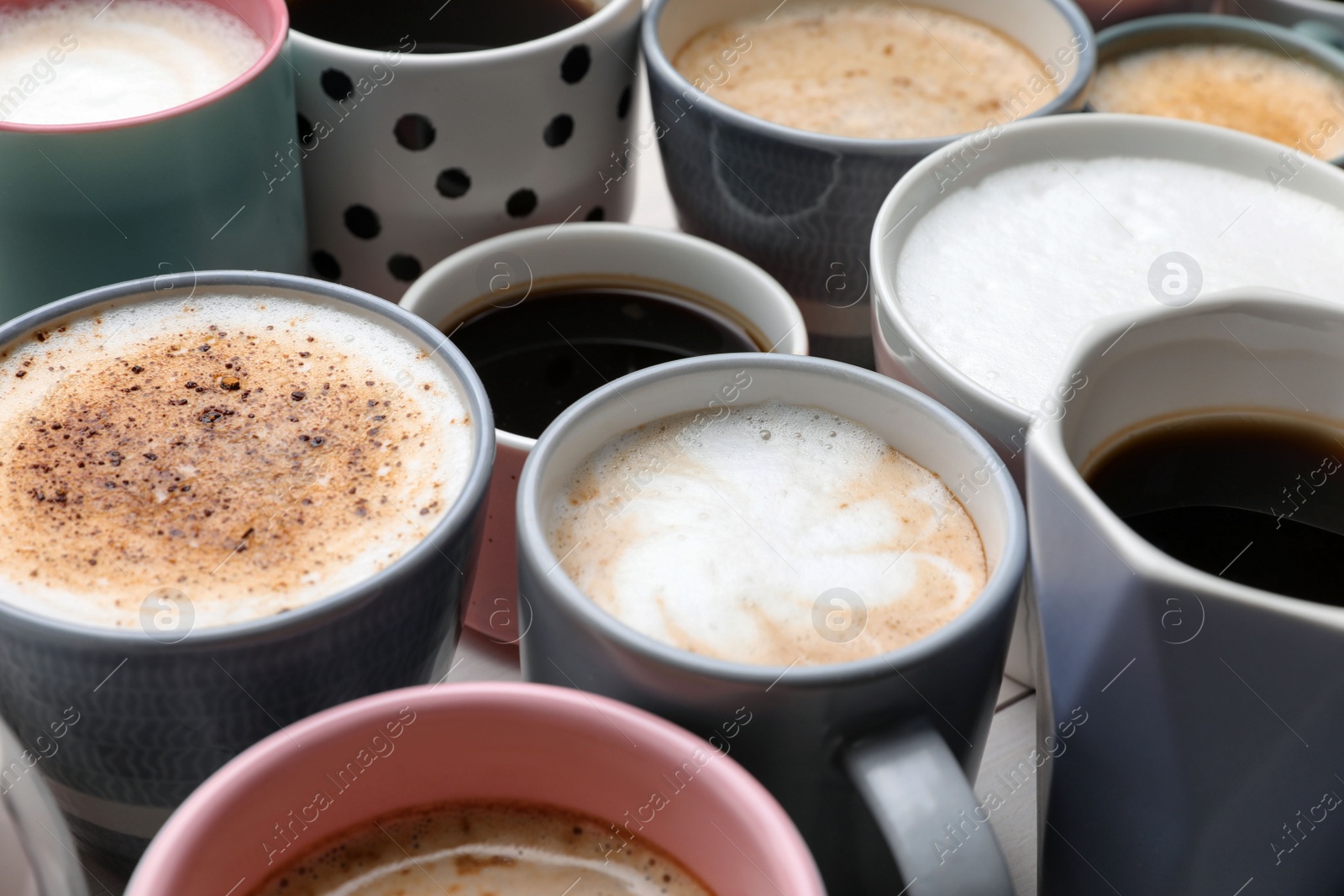Photo of Many different cups with aromatic hot coffee on table, closeup
