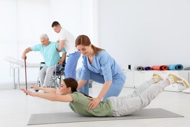 Photo of Professional physiotherapists working with patients in rehabilitation center