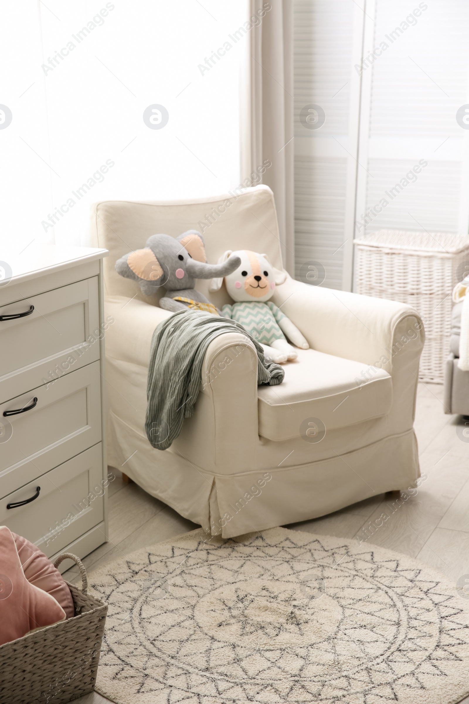 Photo of Comfortable armchair in modern baby room interior