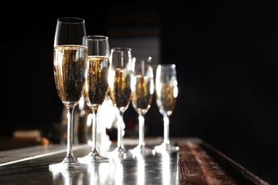 Photo of Glasses of champagne on counter in bar. Space for text