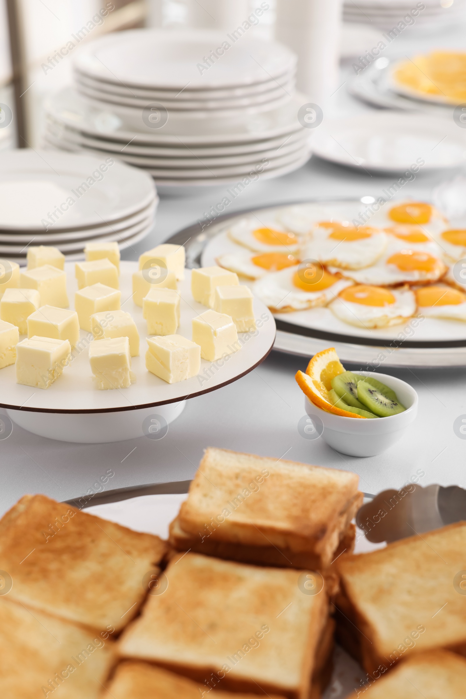 Photo of Clean dishware and different meals for breakfast on white table indoors. Buffet service