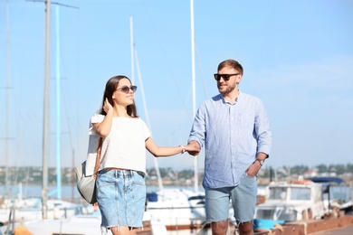 Photo of Young hipster couple in jean clothes on pier