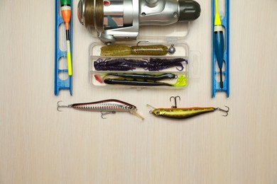 Photo of Different fishing equipment on light wooden table, flat lay. Space for text