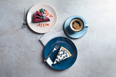 Photo of Flat lay composition with piece of tasty blueberry cake on gray table