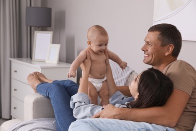 Happy family with their cute baby on sofa in living room