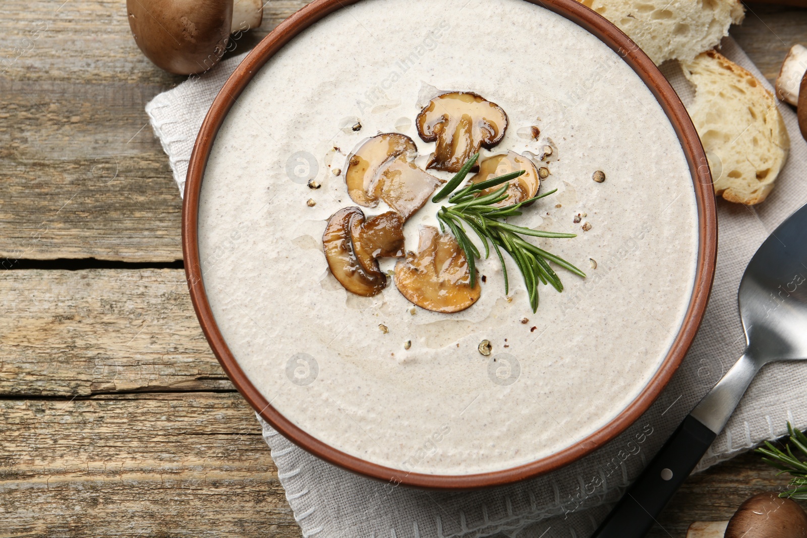 Photo of Fresh homemade mushroom soup served on wooden table, flat lay