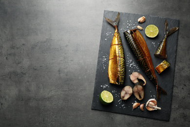 Photo of Tasty smoked fish on grey table, top view. Space for text
