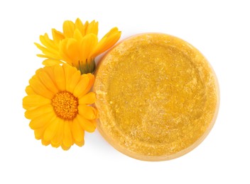 Photo of Yellow solid shampoo bar and flowers on white background, top view. Hair care