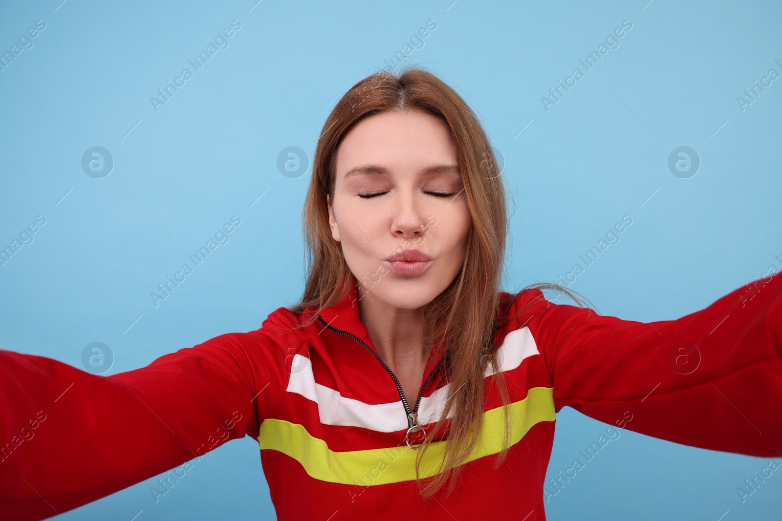 Photo of Beautiful woman taking selfie on light blue background