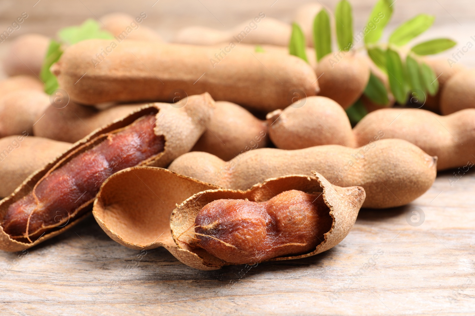 Photo of Delicious ripe tamarinds on wooden table, closeup