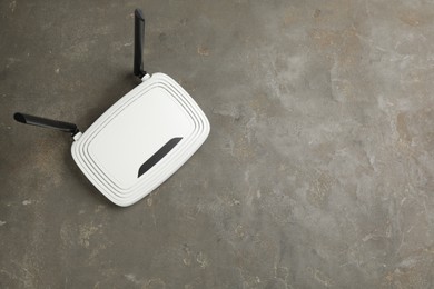 Photo of Modern Wi-Fi router on grey background, top view. Space for text