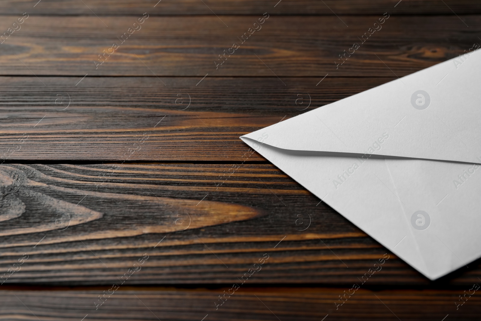 Photo of White paper envelope on wooden background, closeup. Space for text