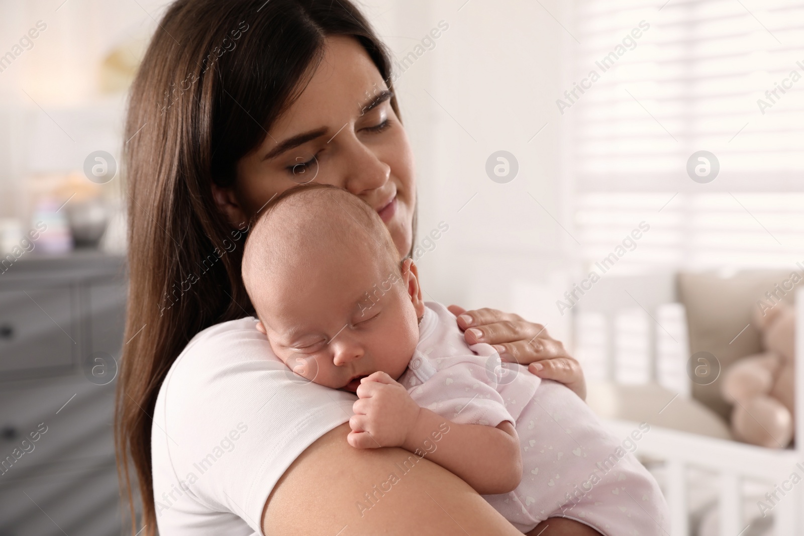 Photo of Young woman with her little baby at home