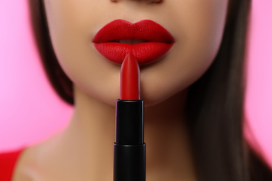 Photo of Woman with red lipstick on pink background, closeup