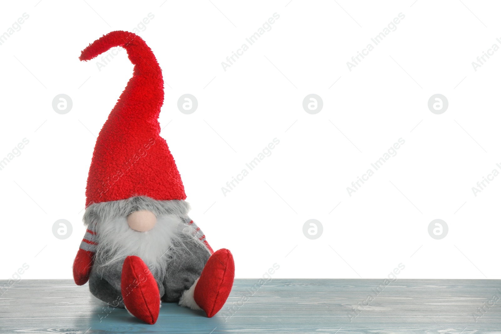 Photo of Funny Christmas gnome on turquoise wooden table against white background. Space for text