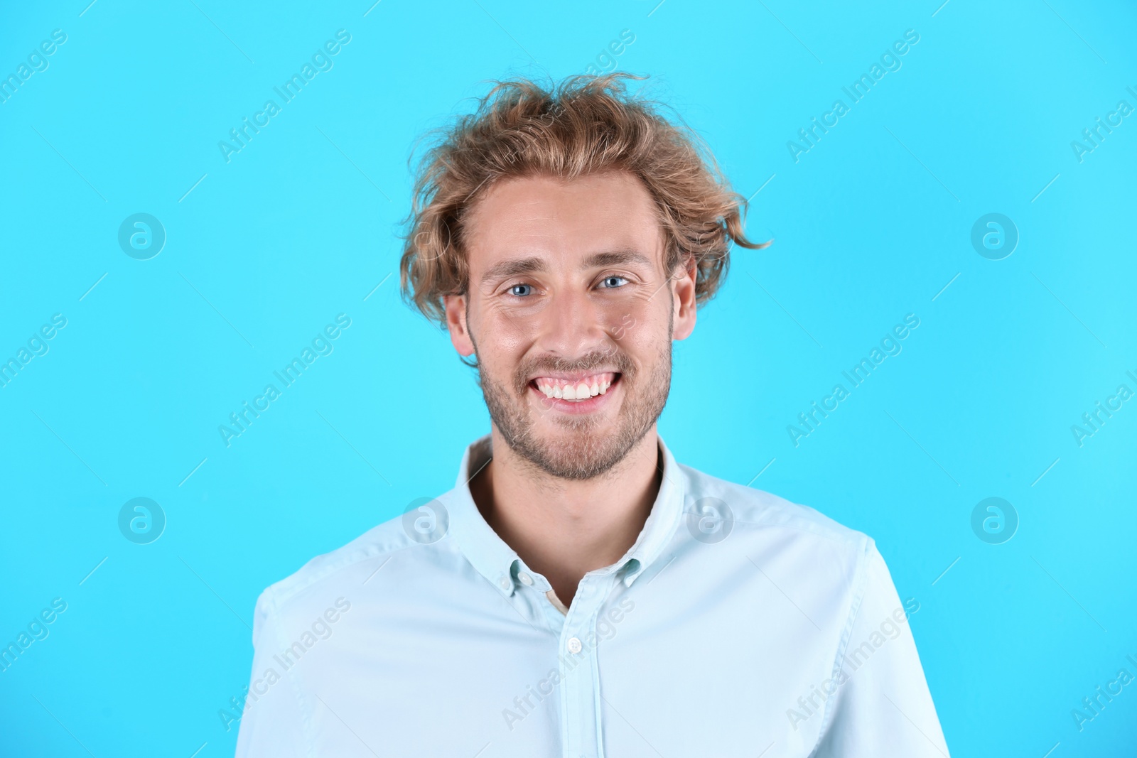 Photo of Handsome young man laughing on color background