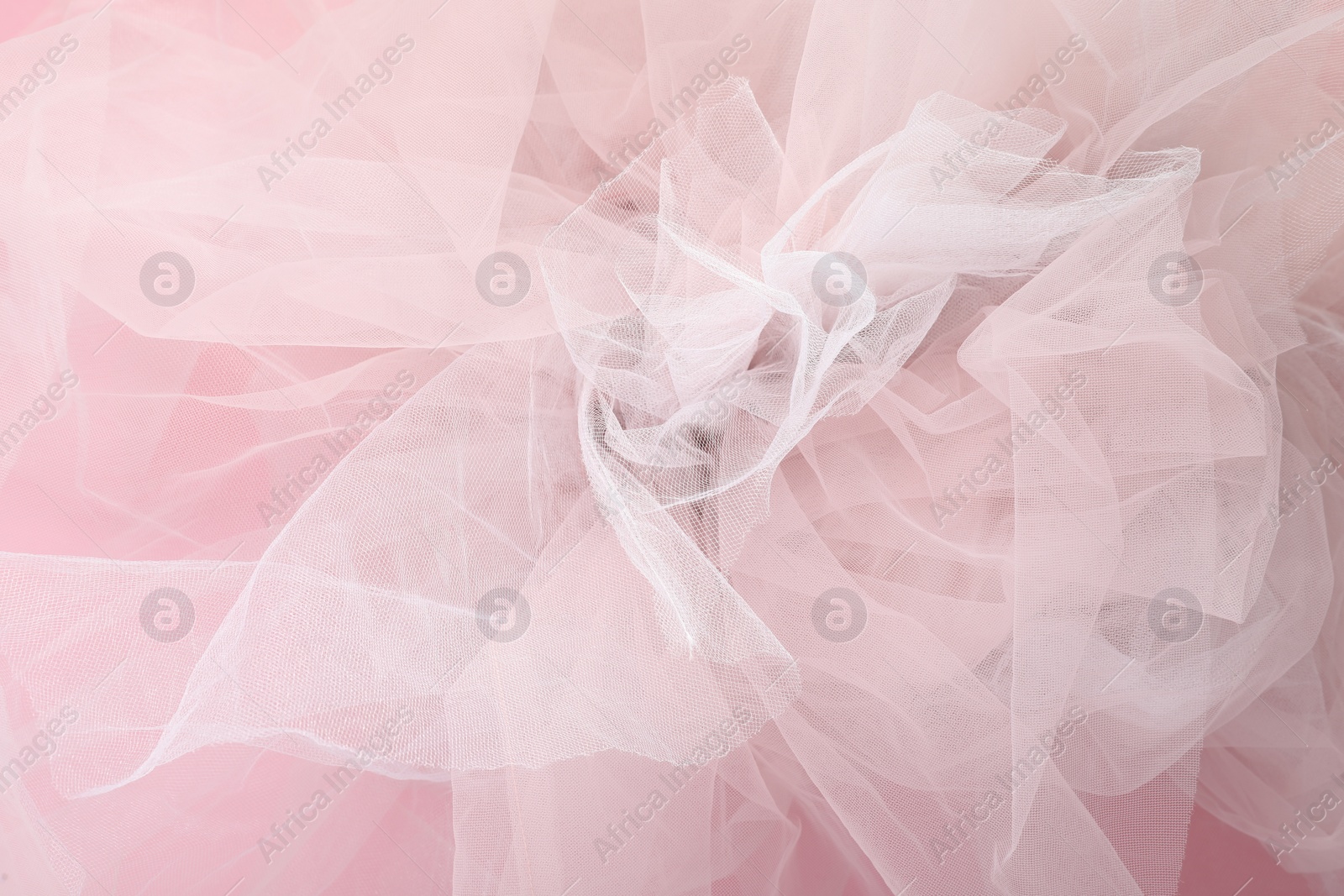 Photo of Beautiful tulle fabric on pink background, closeup