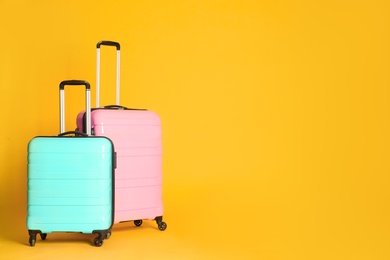 Photo of Travel suitcases on yellow background, space for text. Summer vacation