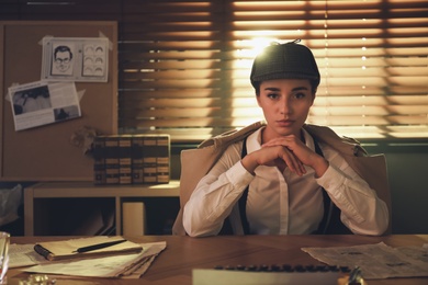 Photo of Old fashioned detective at table in office