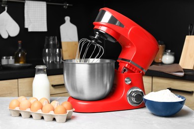 Photo of Modern stand mixer and ingredients on table in kitchen. Home appliance