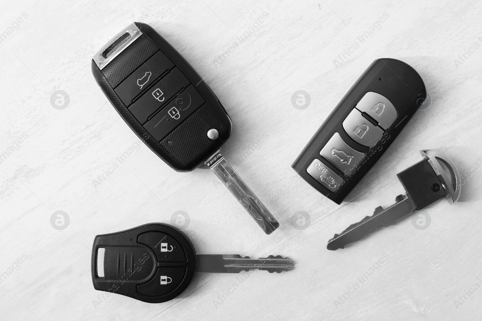 Photo of Flat lay composition with different car keys on light background, top view