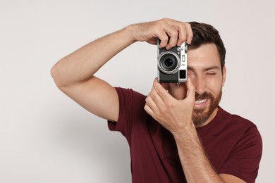 Photo of Man with camera taking photo on white background. Interesting hobby