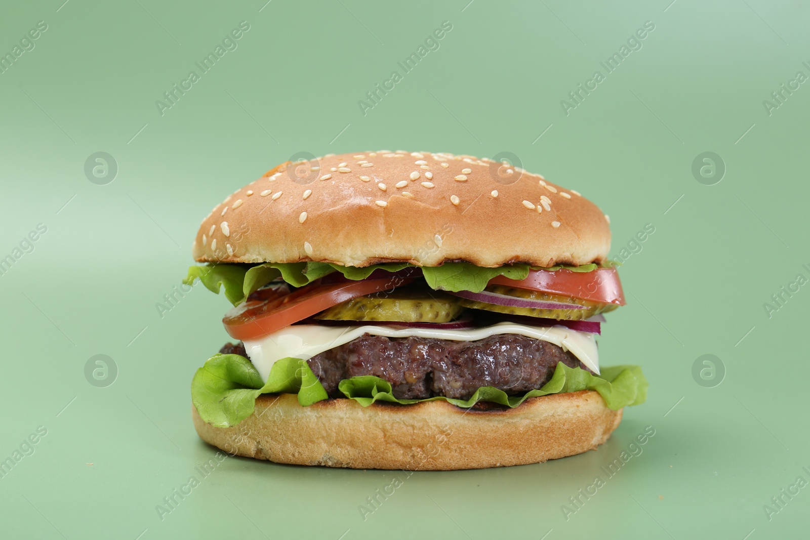 Photo of Burger with delicious patty on green background