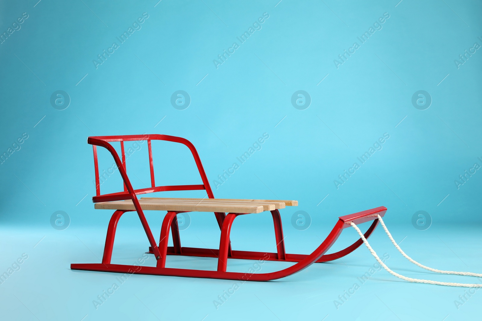 Photo of Sleigh on light blue background. Winter outdoor activity