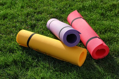 Photo of Bright exercise mats on fresh green grass outdoors