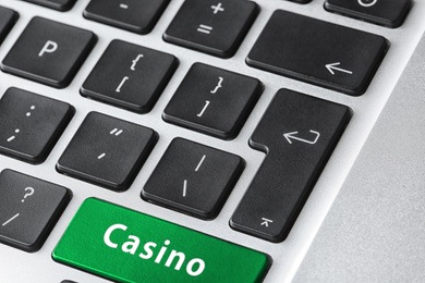 Image of Laptop keyboard with button Casino, closeup. Online games concept