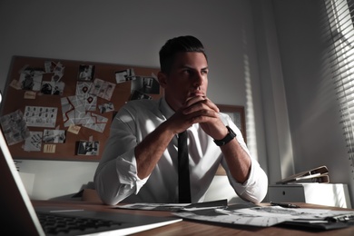 Detective working at desk in his office