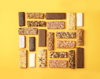 Photo of Flat lay composition with protein bars on color background