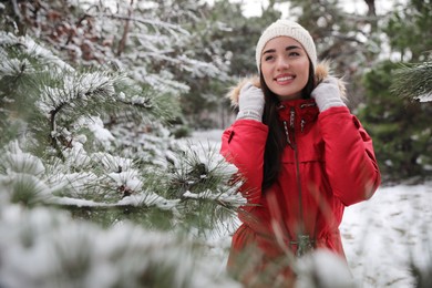 Photo of Happy young woman near tree in forest on winter day