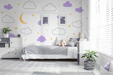 Modern child room interior with comfortable bed near window 