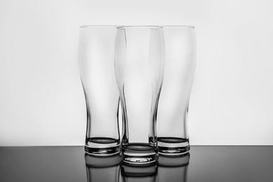 Photo of Empty clear beer glasses on white background