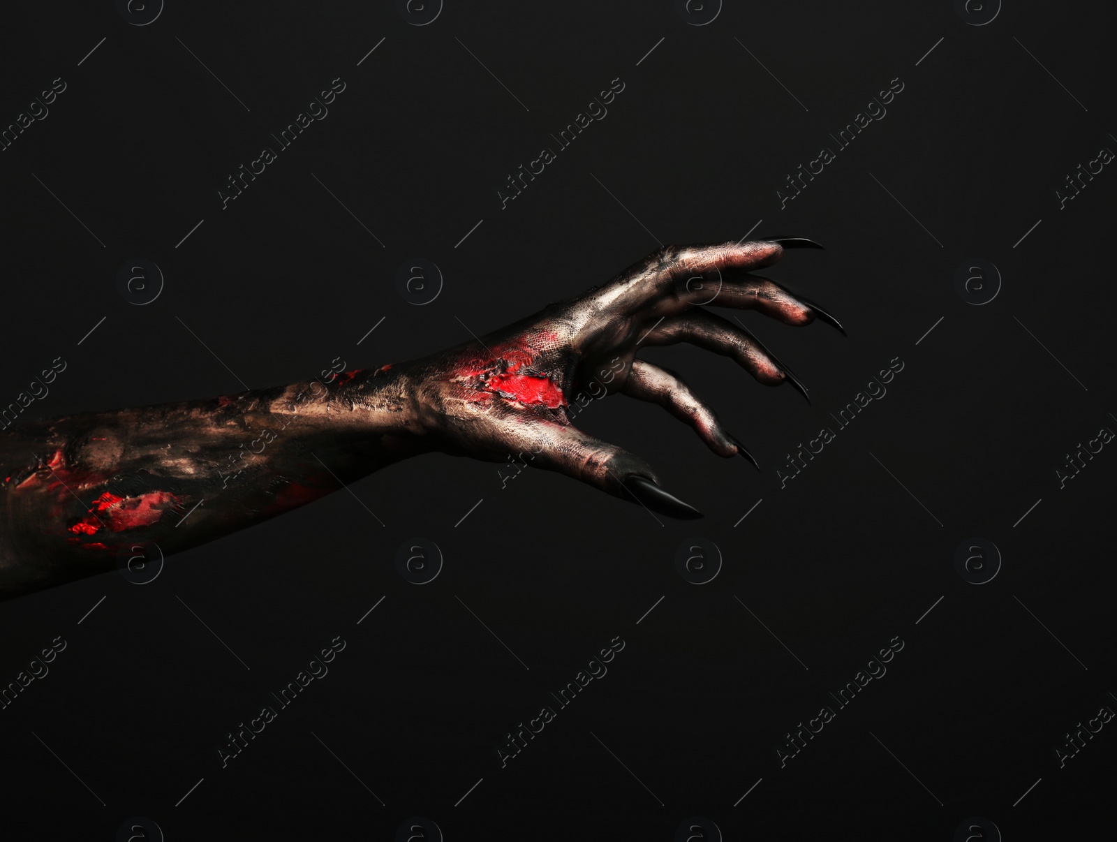 Photo of Scary monster on black background, closeup of hand with space for text. Halloween character