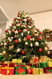 Decorated Christmas tree with gift boxes in room, low angle view