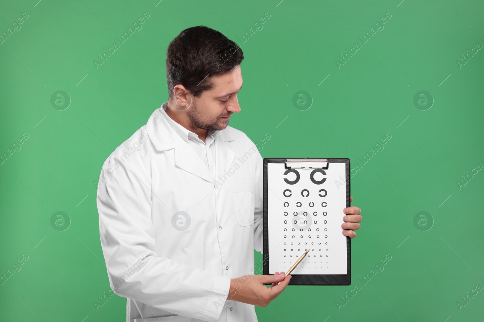 Photo of Ophthalmologist pointing at vision test chart on green background