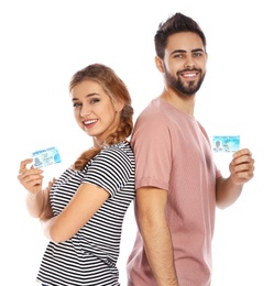 Happy young people with driving licenses on white background