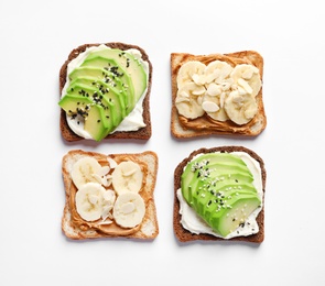 Photo of Tasty toast bread with banana and avocado slices on white background