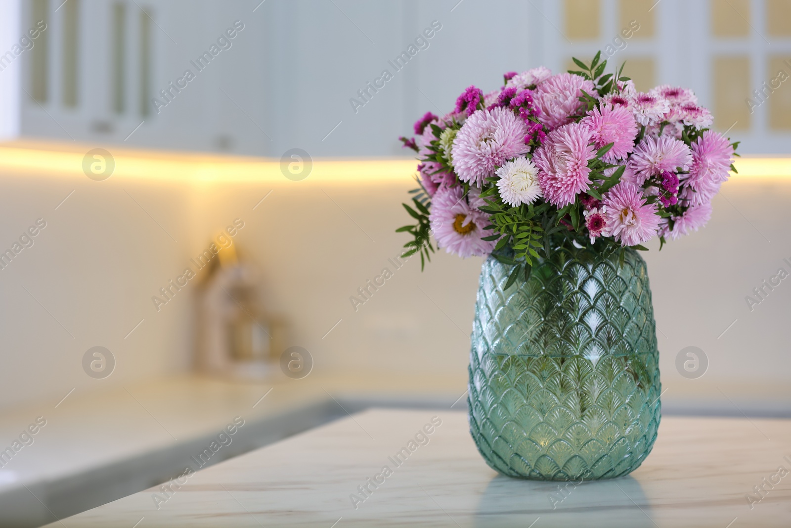 Photo of Vase with beautiful chrysanthemum flowers on table in kitchen, space for text. Interior design