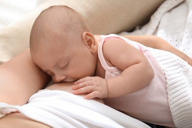 Photo of Young woman breastfeeding her little baby at home, above view
